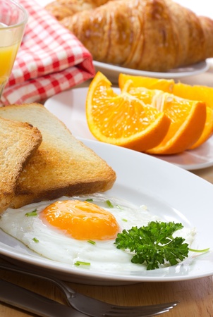 breakfast with  fried egg,  juice and croissantの写真素材