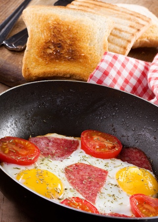 breakfast with  fried eggs with vegetables, bacon and toastsの写真素材