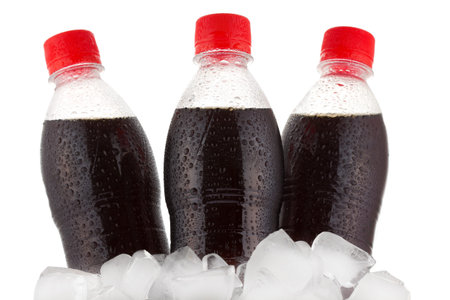 bottles of cola in ice on white backgroundの写真素材