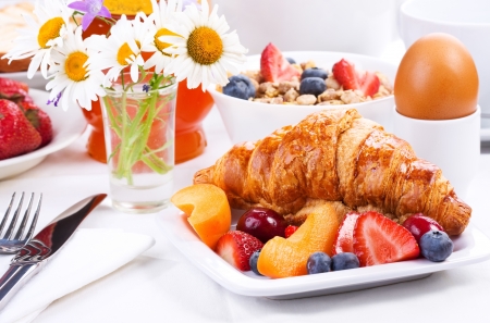 breakfast with fresh croissants, berries and fruitsの写真素材