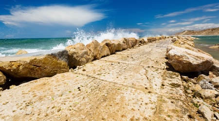 wave splash against breakwater made of stonesの写真素材