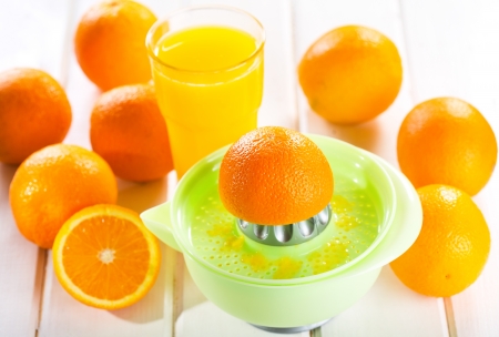 orange squeezer with fresh fruits and glass of juiceの写真素材