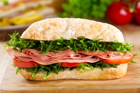 sandwich with bacon and vegetables on wooden tableの写真素材