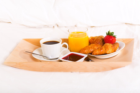 breakfast in bed with coffee, croissants and juiceの写真素材
