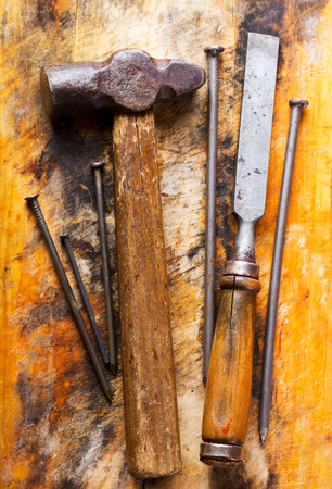 old hammer and chisel on wooden backgroundの写真素材