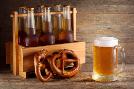 mug of beer with bottles in wooden boxの写真素材