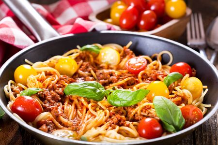 pan with spaghetti bolognese on wooden tableの写真素材