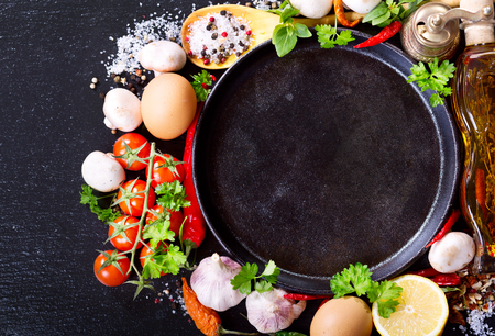 empty pan with various products for cooking on dark boardの写真素材