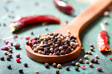 mix of various peppers in a spoon on rusty backgroundの写真素材
