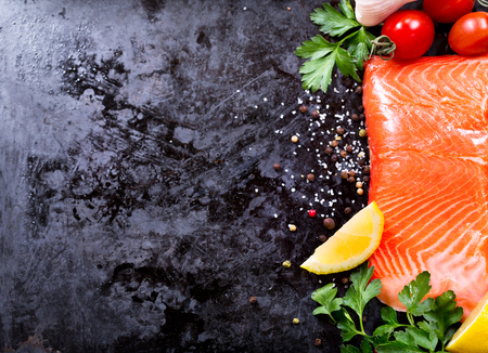 fresh salmon with vegetables on dark backgroundの写真素材