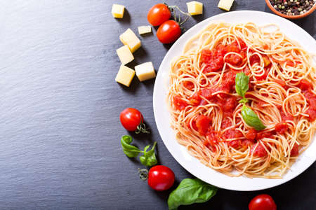 plate of pasta with tomato sauce on dark backgroundの写真素材