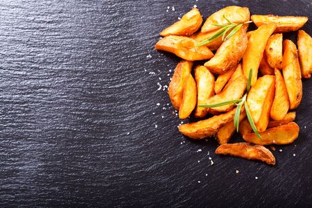 roasted potatoes with rosemary on dark backgroundの写真素材
