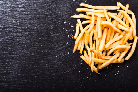 French fries potatoes on dark background