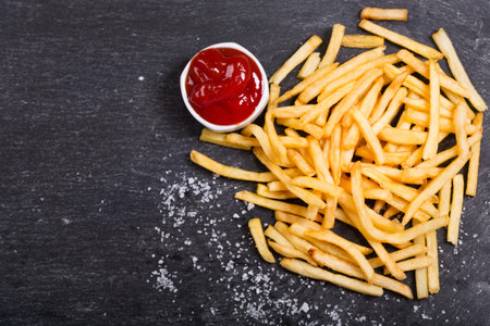 French fries with ketchup on dark table