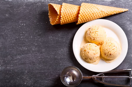 plate of ice cream scoops with waffle cones  on dark background