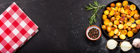 pan of roasted potatoes with rosemary on dark tableの写真素材