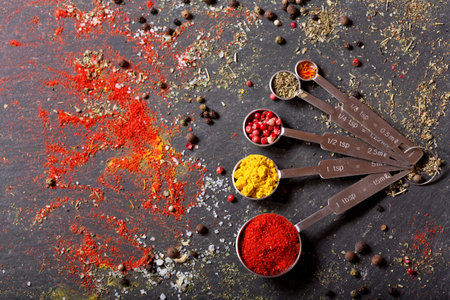 various  spices for cooking on dark table, top view