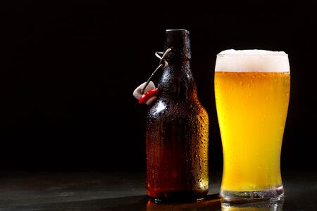 bottle and glass of beer on dark backgroundの写真素材