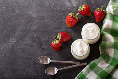 yogurt in a glass jars with fresh strawberries, top viewの写真素材