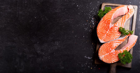 fresh salmon steaks on a wooden board, top viewの写真素材