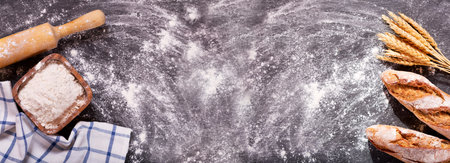 bread with wheat ears on dark board, top view