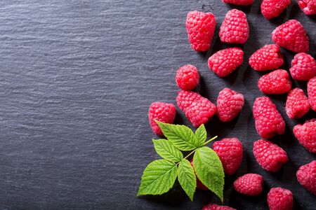 fresh raspberries with leaves on dark background, top viewの写真素材