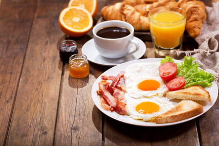 breakfast with croissants, coffee, juice and fresh fruits on wooden tableの写真素材