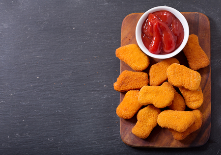 chicken nuggets with ketchup on wooden board, top viewの写真素材