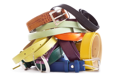 heap of various types of leather belts isolated on white backgroundの写真素材