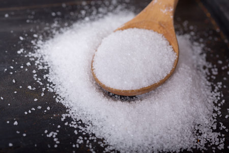 sea salt in a wooden spoon on wooden table