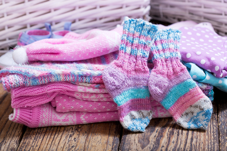 various baby clothes on wooden tableの写真素材