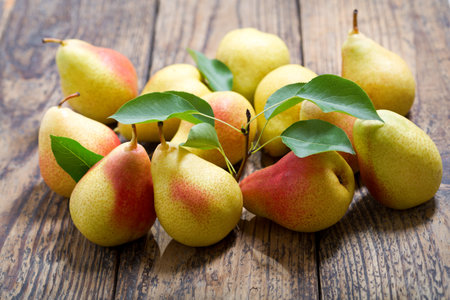 fresh pears with leaves on wooden table