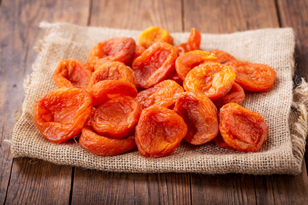 heap of dried apricots on wooden tableの写真素材