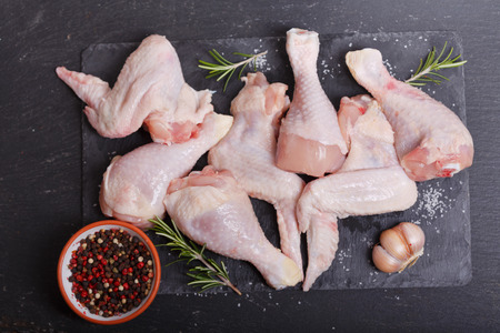 fresh chicken meat with ingredients for cooking on dark board, top viewの写真素材