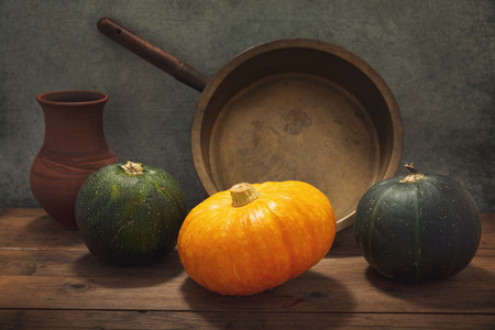 still life with pumpkin and fresh vegetables on a wooden tableの写真素材