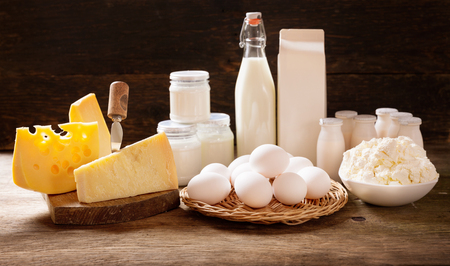 various types of dairy products : milk, cheese, cottage cheese, eggs, yogurt on rustic wooden tableの写真素材