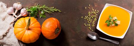 bowl of pumpkin soup with ingredients for cooking, top viewの写真素材