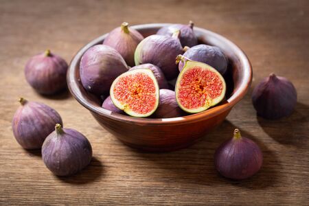 bowl of fresh figs fruit on wooden table の写真素材