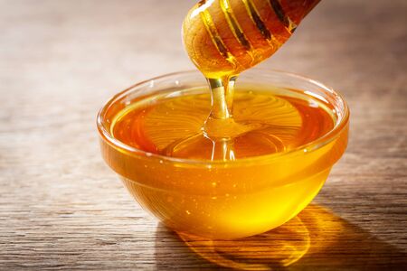 close up of pouring honey into bowlの写真素材