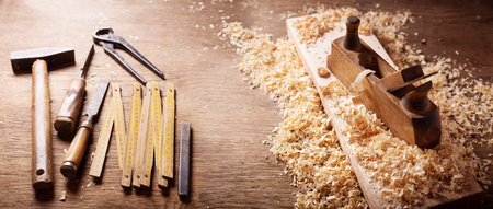 old tools: wooden plane, hammer, chisel in a carpentry workshop on wooden table
