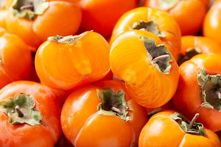 close up of fresh ripe persimmon fruit as backgroundの写真素材