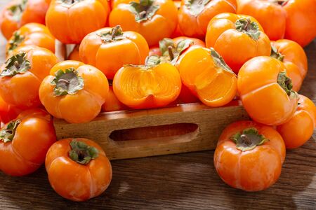 fresh ripe persimmon fruit in a wooden boxの写真素材
