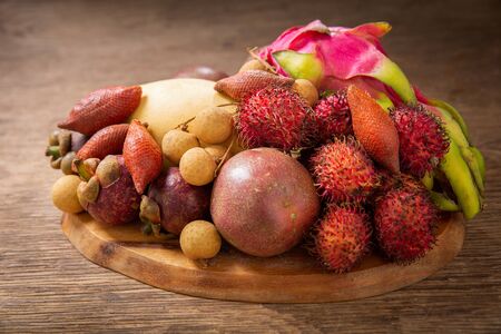 Mix of ripe exotic fruits on wooden boardの写真素材