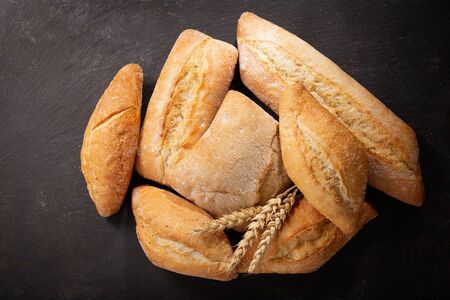 fresh bread with wheat ears on a dark background, top viewの写真素材