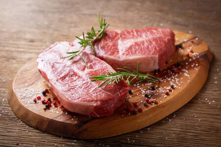 fresh meat with rosemary and spices on a wooden boardの写真素材