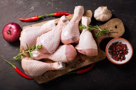 fresh chicken meat with rosemary and spices on wooden board, top viewの写真素材