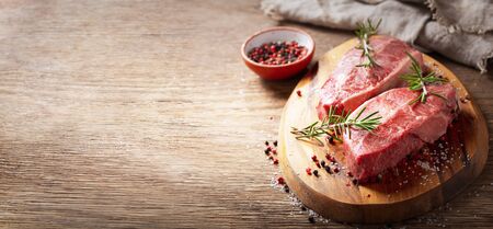 fresh meat with rosemary and spices on a wooden boardの写真素材