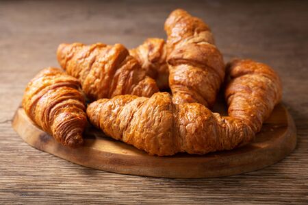 close up of fresh croissants on a wooden boardの写真素材
