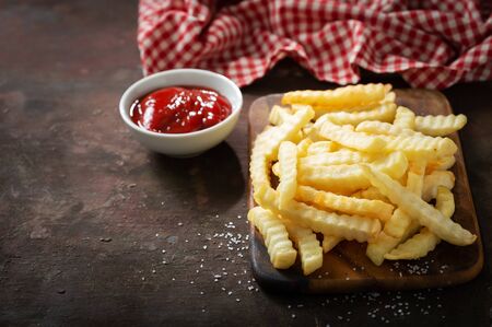 French fries with ketchup on wooden boardの写真素材