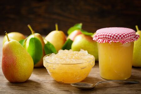 bowl of pear jam and fresh fruits on a wooden tableの写真素材